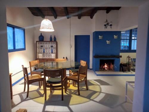 une salle à manger avec une table, des chaises et une cheminée dans l'établissement Casa de Campo La Magdalena, à Tunuyán