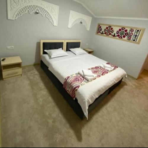 Un dormitorio con una cama grande en una habitación. en Green House ECO HOTEL, en Samarkand