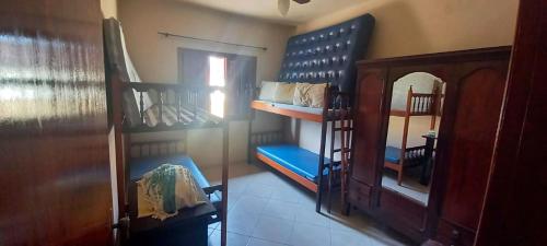 een kamer met 2 stapelbedden en een spiegel bij Incrivel casa a 280 m do mar em Peruibe SP in Peruíbe