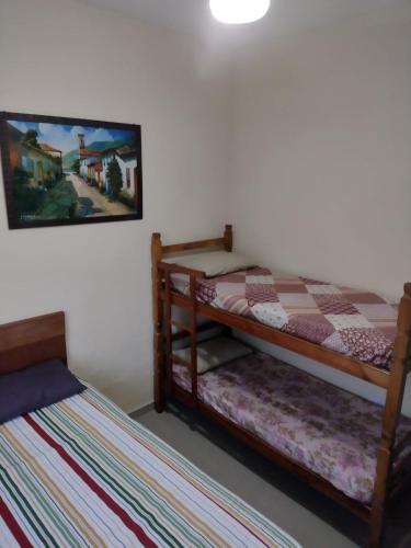 a bedroom with two bunk beds and a painting on the wall at Casarão Familiar Eixo Cabo Frio Buzios com piscinão in Cabo Frio