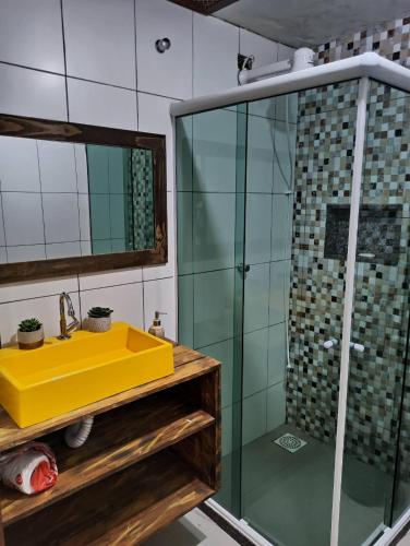 a bathroom with a yellow sink and a glass shower at Casarão Familiar Eixo Cabo Frio Buzios com piscinão in Cabo Frio