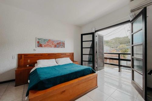 a bedroom with a bed and a large window at Búzios Centro Hotel in Búzios