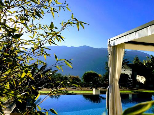 a view of a swimming pool with mountains in the background at Les Suites du Lac in Aix-les-Bains