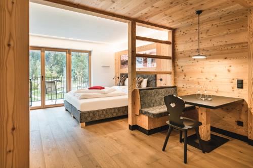 ein Schlafzimmer mit einem Bett und einem Schreibtisch mit einem Stuhl in der Unterkunft Residence Altea in St. Ulrich in Gröden