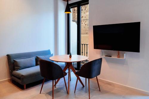 a living room with a table and chairs and a couch at Apartamentos Plaza de España 6 in Villanueva de la Serena