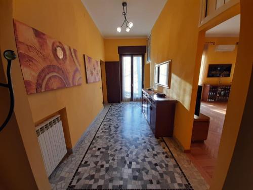 um corredor com paredes amarelas e piso em azulejo em Casa vacanze - House Stop and Go em Busto Arsizio