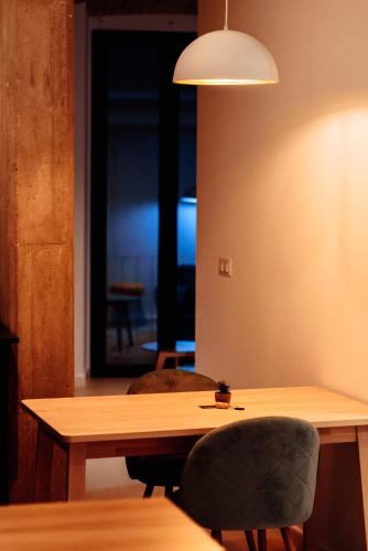 a wooden table with two chairs and a lamp at Apartamentos Plaza de España 6 in Villanueva de la Serena