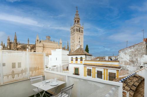 a balcony with a view of a building with a clock tower at Historic Building Cathedral in Seville