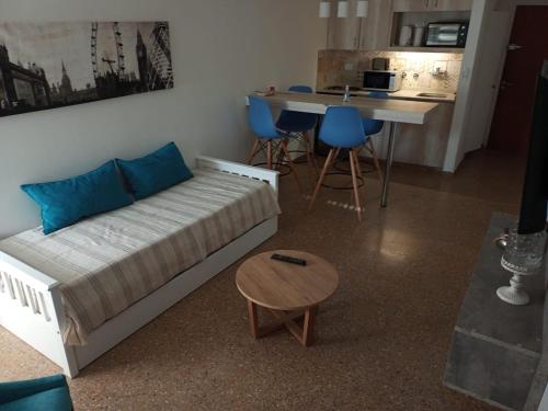 a living room with a bed and a table and a kitchen at Apart Plaza in Río Cuarto