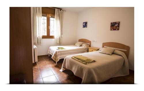 a room with two beds and a window at Apartamento Alcala de la selva in Alcalá de la Selva