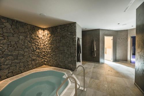 a bathroom with a hot tub in a stone wall at Residence Altea in Ortisei
