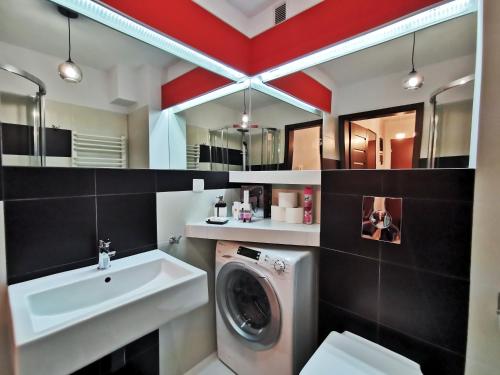 een badkamer met een wasmachine en een wastafel bij Apartament 33 in Krakau