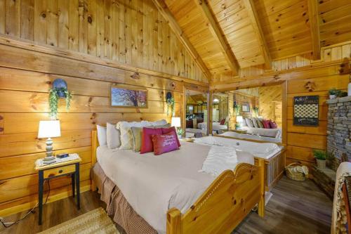 um quarto com uma cama grande num chalé de madeira em Do Not Disturb - Pigeon Forge Smoky Mountain Studio Cabin, Hot Tub, Fireplace em Pigeon Forge