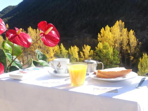 ein Tisch mit einer Tasse Orangensaft und einem Stück Brot in der Unterkunft Apartamentos El Pajar Alcala de la Selva in Alcalá de la Selva
