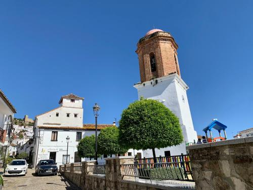 un edificio con una torre de reloj y una valla en El estudio - beautiful apartment in historic old town, en Jimena de la Frontera