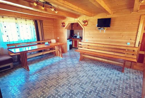 une chambre avec des bancs en bois et une télévision dans une cabine dans l'établissement Cabanele FloriCrin - Cabana 2, à Mărişel
