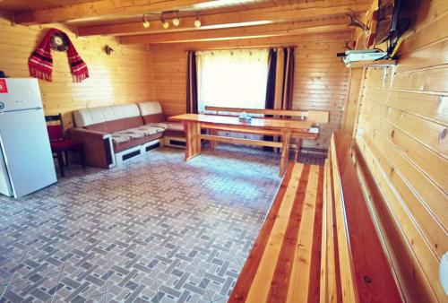 une chambre avec une table et un banc dans une cabine dans l'établissement Cabanele FloriCrin - Cabana 2, à Mărişel