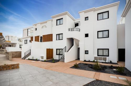 a white apartment building with a courtyard at Shambhala Fuerteventura in Parque Holandes