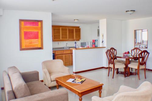 a kitchen and a living room with a table and chairs at Portal del Rodeo ApartaHotel in Medellín