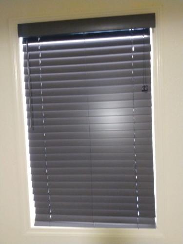 a window with blinds on it in a room at Green Garden Inn in Greensboro