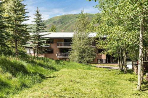 a building in the middle of a field with trees at 700 Monarch 104 in Aspen