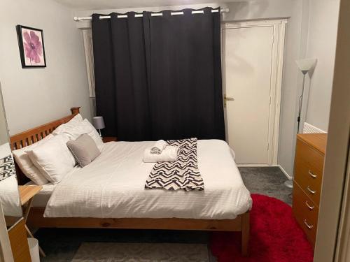 a bedroom with a bed with a black curtain at CyCy Apartment in Aberdeen