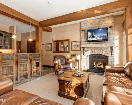 a living room with a fireplace with a tv above it at Private Condos at Hotel Park City in Park City