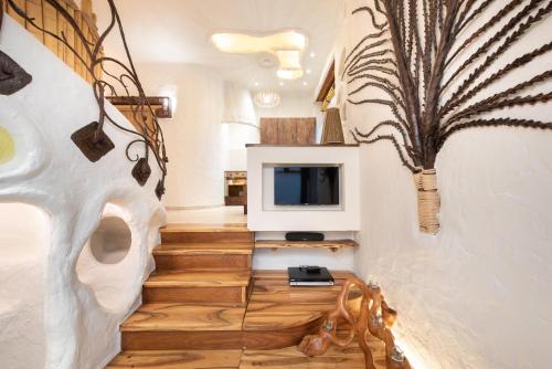 uma sala de estar com uma escada com uma televisão e uma planta aumedumed em Krakowhomes em Cracóvia