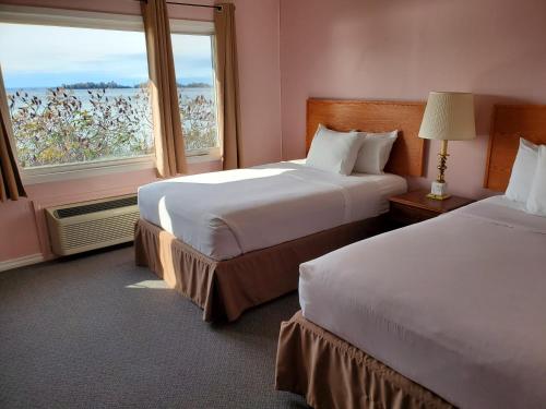 a hotel room with two beds and a window at Carolyn Beach Inn in Thessalon