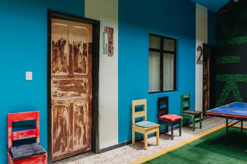 una habitación con sillas coloridas y una puerta en XanticoHostal, en Ipiales