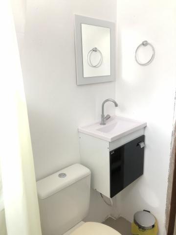 a white bathroom with a toilet and a sink at Casa Jequitibá Quartos Mobiliados in Macaé