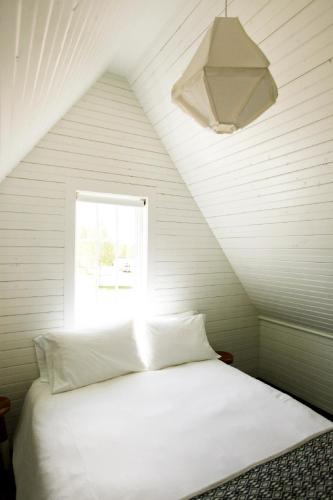 a white bed in a room with a window at Surf Hotel & Chateau in Buena Vista