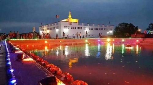 a large fountain with lights in front of a building at Hotel Kanthak in Lumbini