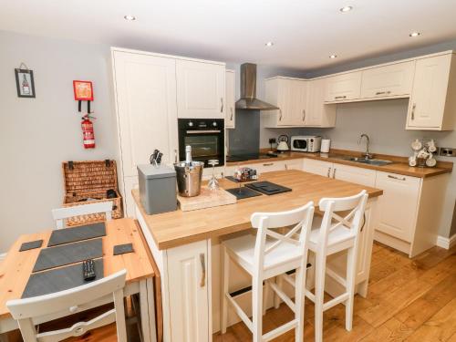a kitchen with a wooden island with a counter top at Haddef in Nefyn