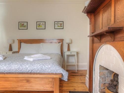a bedroom with a bed and a fireplace at Youngs Cottage in Port Fairy