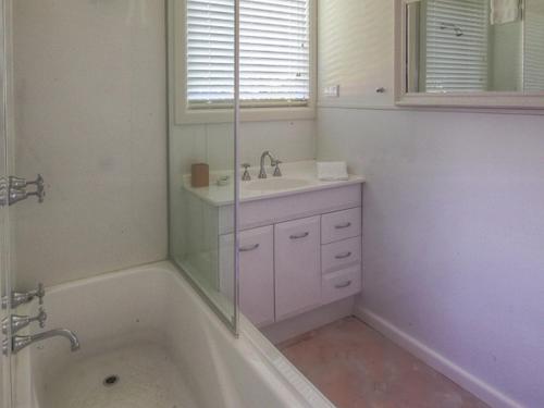 Un baño blanco con bañera y lavabo. en Youngs Cottage, en Port Fairy