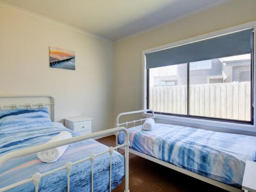 a bedroom with a bed and a window at Wings and Waves in Port Fairy