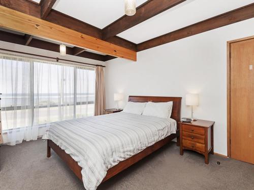 a bedroom with a bed and a large window at Swimmers Rest 1 Bedroom in Port Fairy