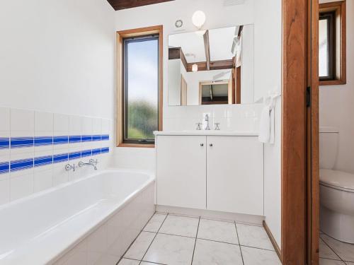 a bathroom with a tub and a sink and a toilet at Swimmers Rest 1 Bedroom in Port Fairy
