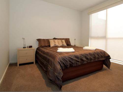 a bedroom with a large bed and a window at Aqua Luna in Port Fairy