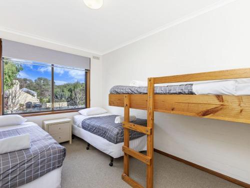 sypialnia z 2 łóżkami piętrowymi i oknem w obiekcie Eastern Beach Unit 6 w mieście Port Fairy