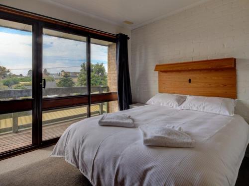 a bedroom with a bed and a large window at Malseeds in Port Fairy