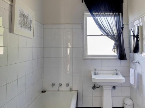 ein weißes Badezimmer mit einer Badewanne und einem Waschbecken in der Unterkunft Mary Grant in Port Fairy