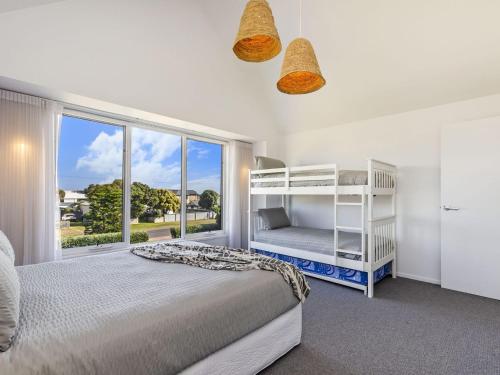 Un dormitorio con una cama y una ventana grande. en East Beach Retreat, en Port Fairy