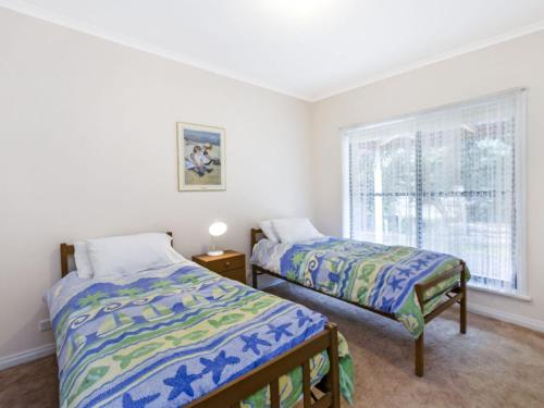 a bedroom with two beds and a window at Kurrawa in Port Fairy