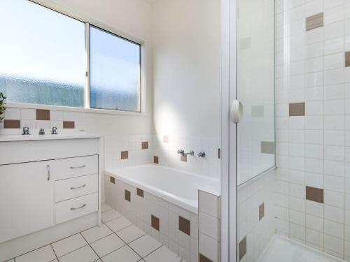 a white bathroom with a tub and a sink at Julieanne in Port Fairy