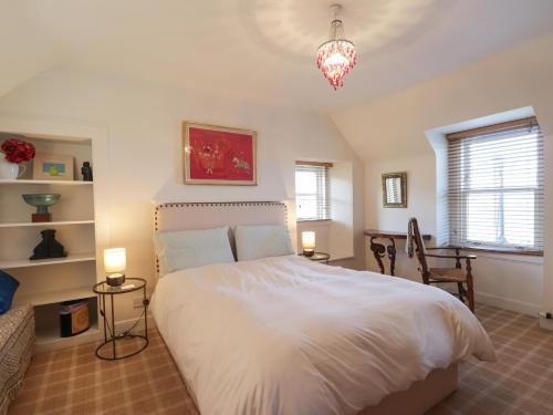 een slaapkamer met een wit bed en 2 lampen bij Seaview in Nairn