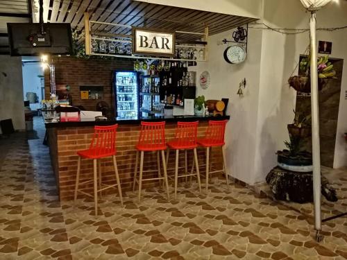 a bar with red bar stools in a restaurant at Club campestre el Peñón de Apulo in Apulo
