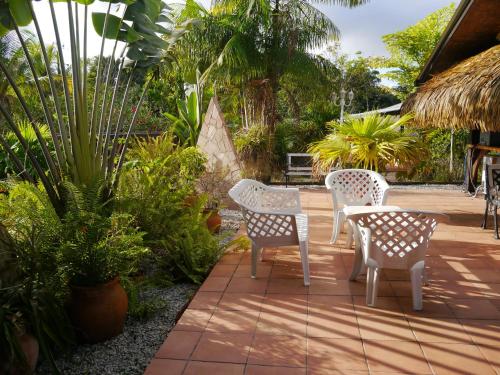 a patio with a table and chairs and plants at Hotel La Marmotte in Matoury