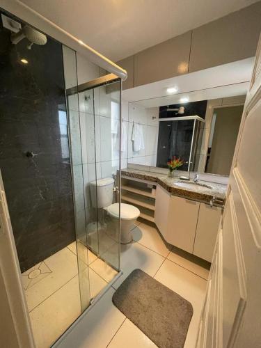 a bathroom with a glass shower and a toilet at APARTAMENTO EM LOCAL PRIVILEGIADO in Maceió